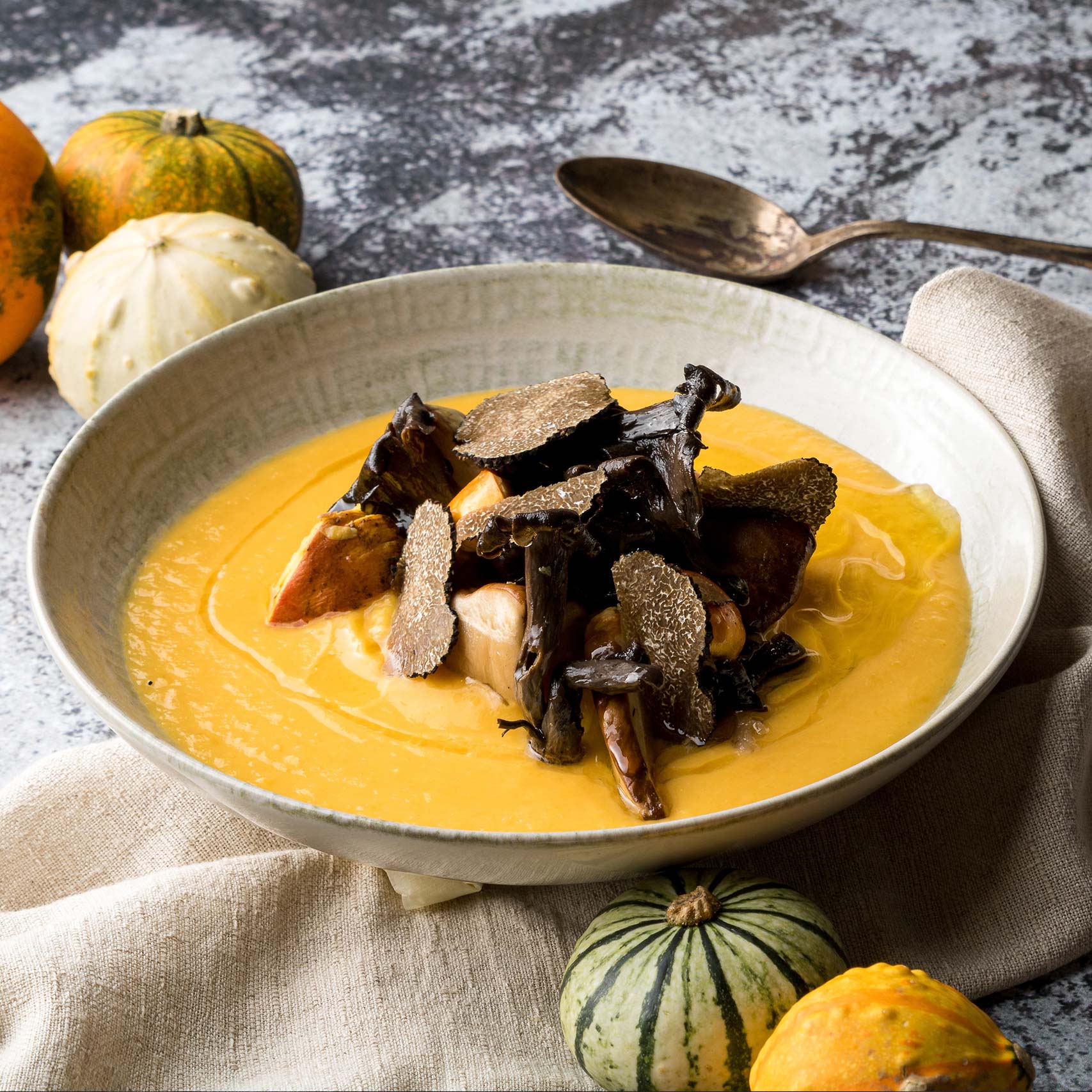 A single Monstera leaf in a clear glass vase against a white background.