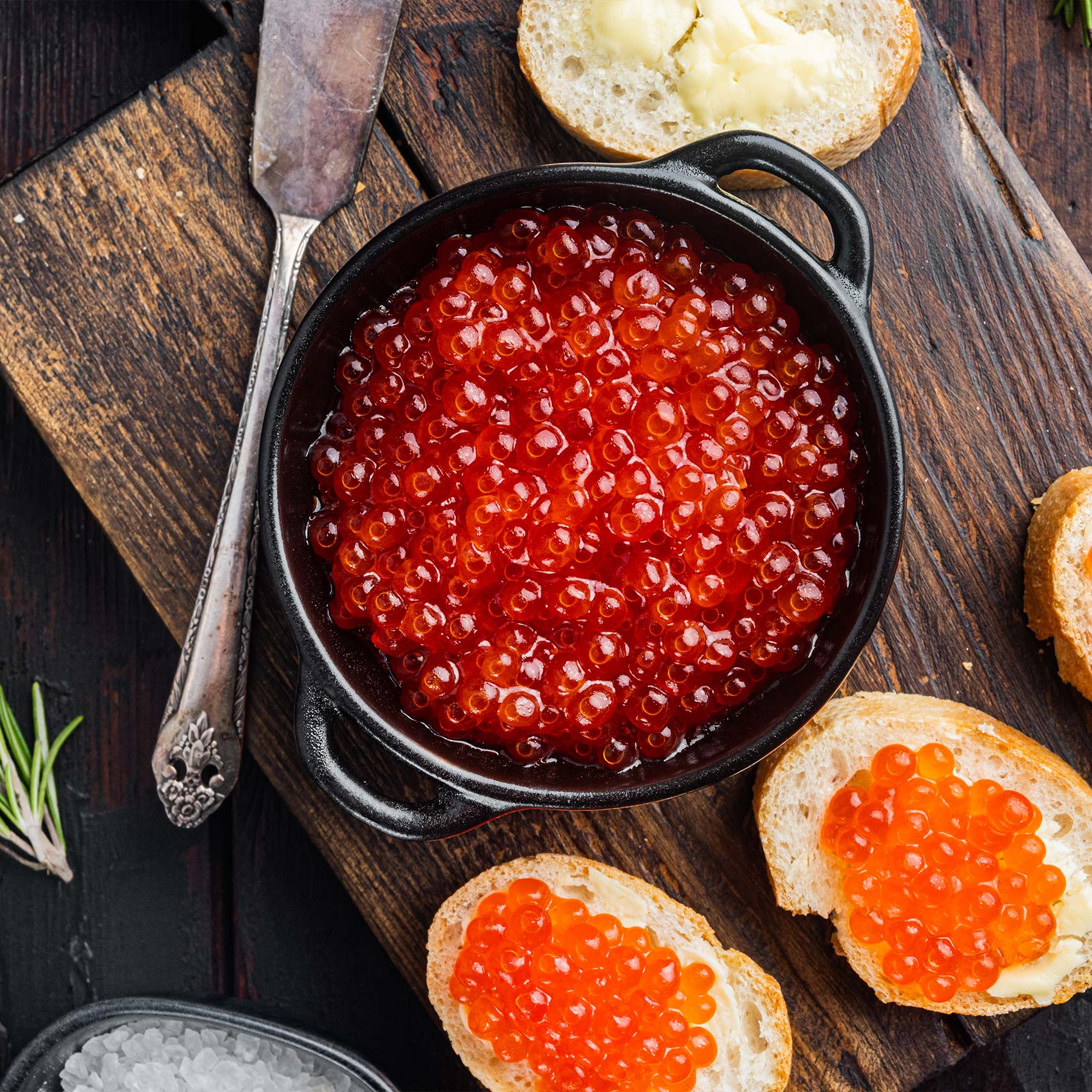 A single green leaf in a clear glass of water on white background.