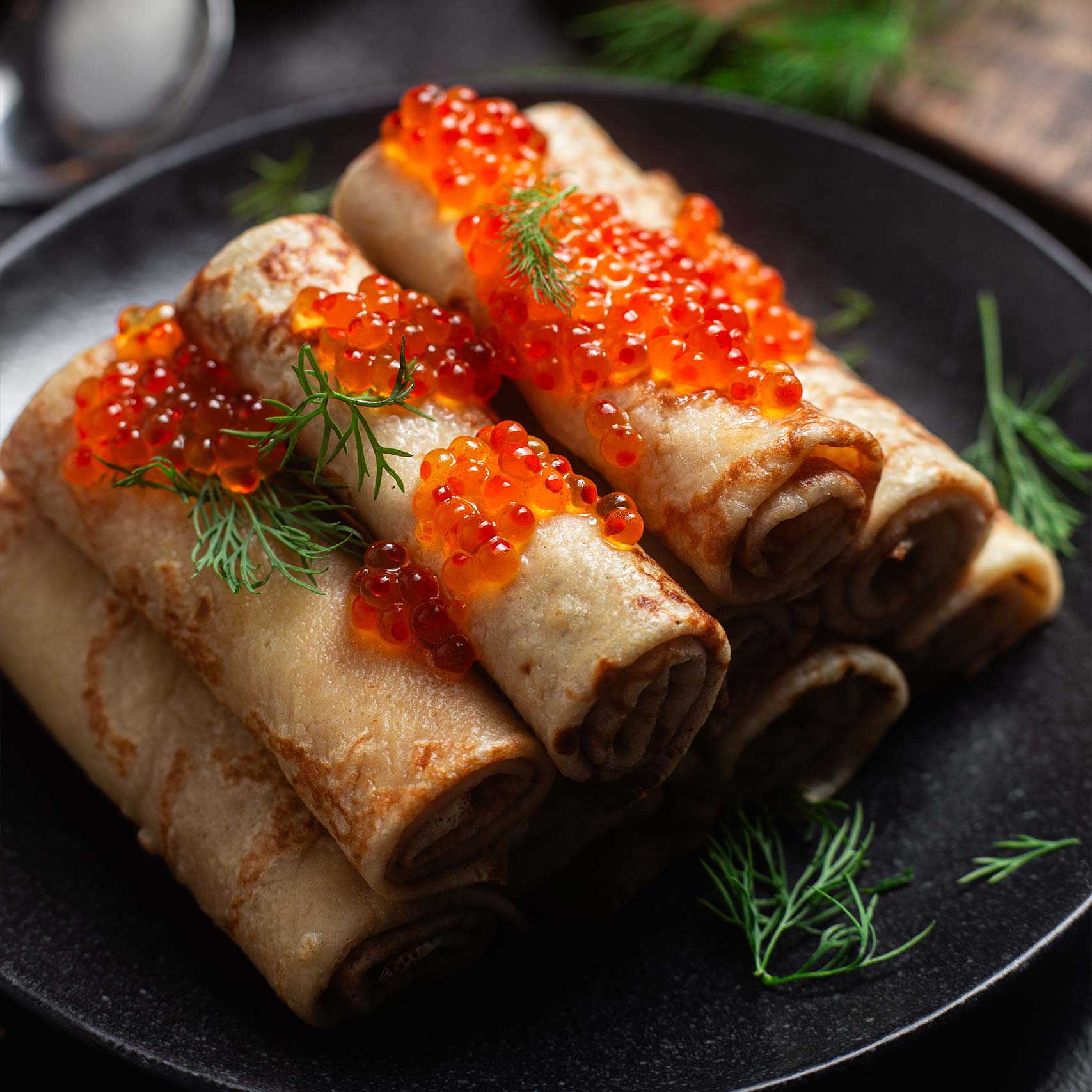 A single Monstera leaf in a clear glass vase against a white background.