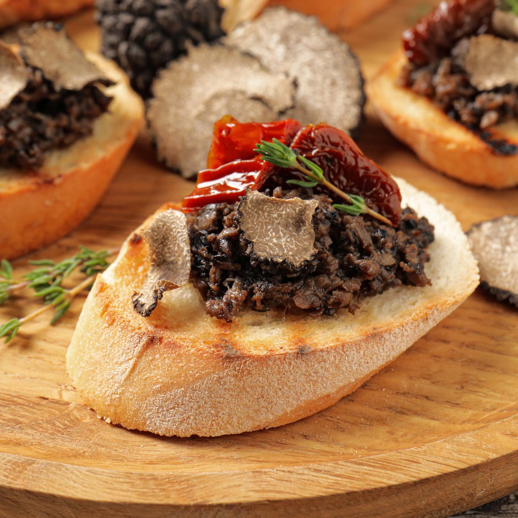 A single Monstera leaf in a clear glass vase against a white background.