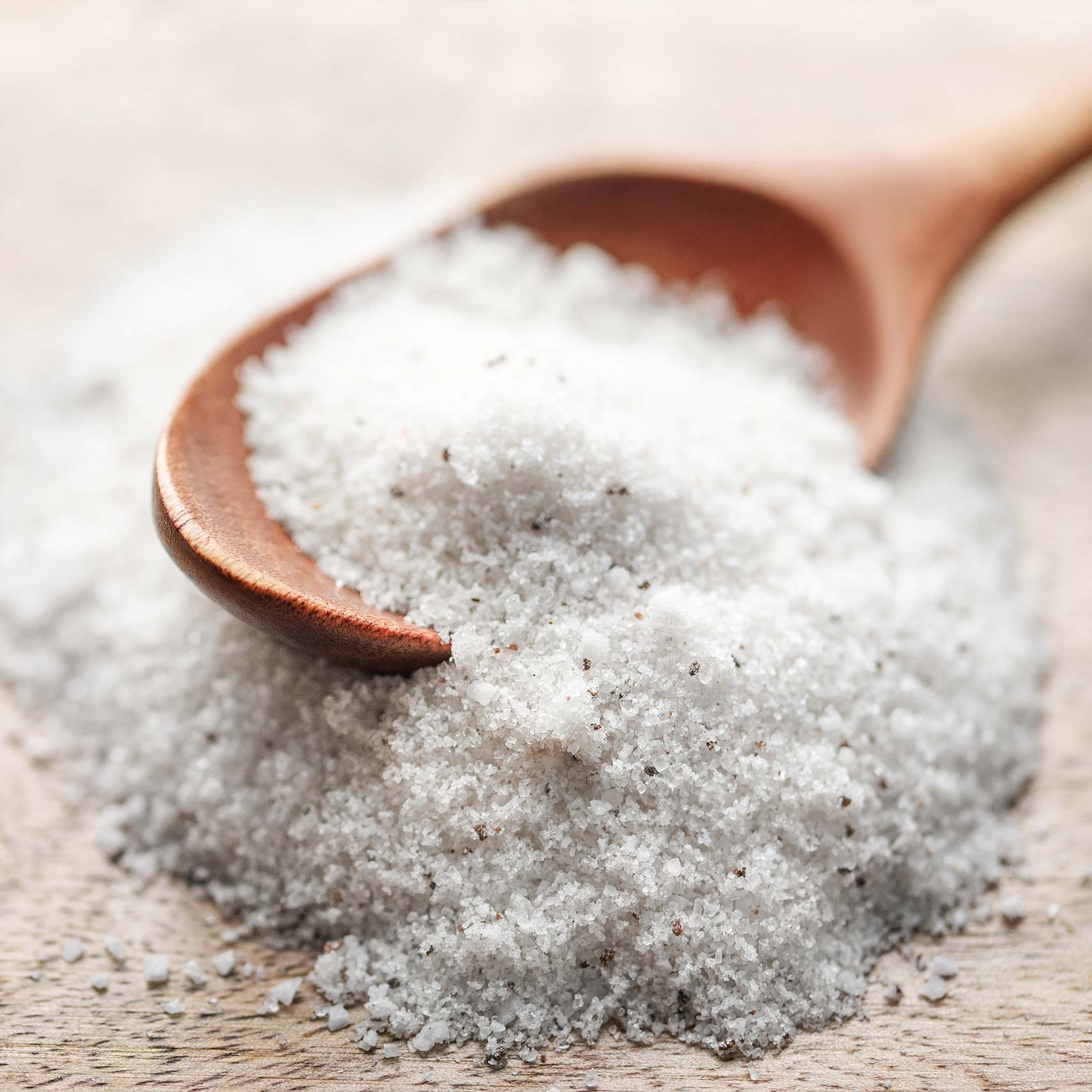A single green leaf in a clear glass of water on white background.
