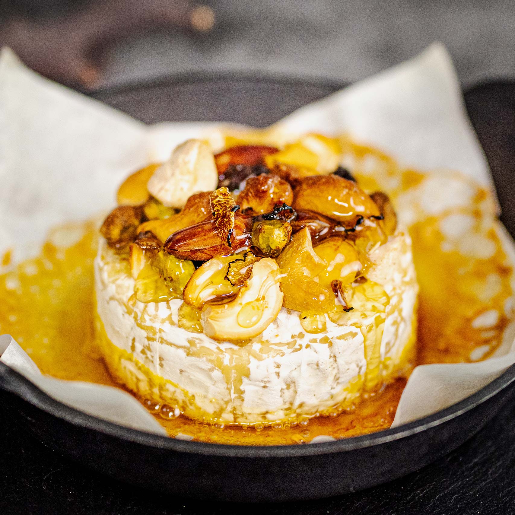 A single Monstera leaf in a clear glass vase against a white background.