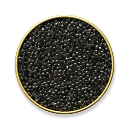 Black caviar in a gold bowl on a white background